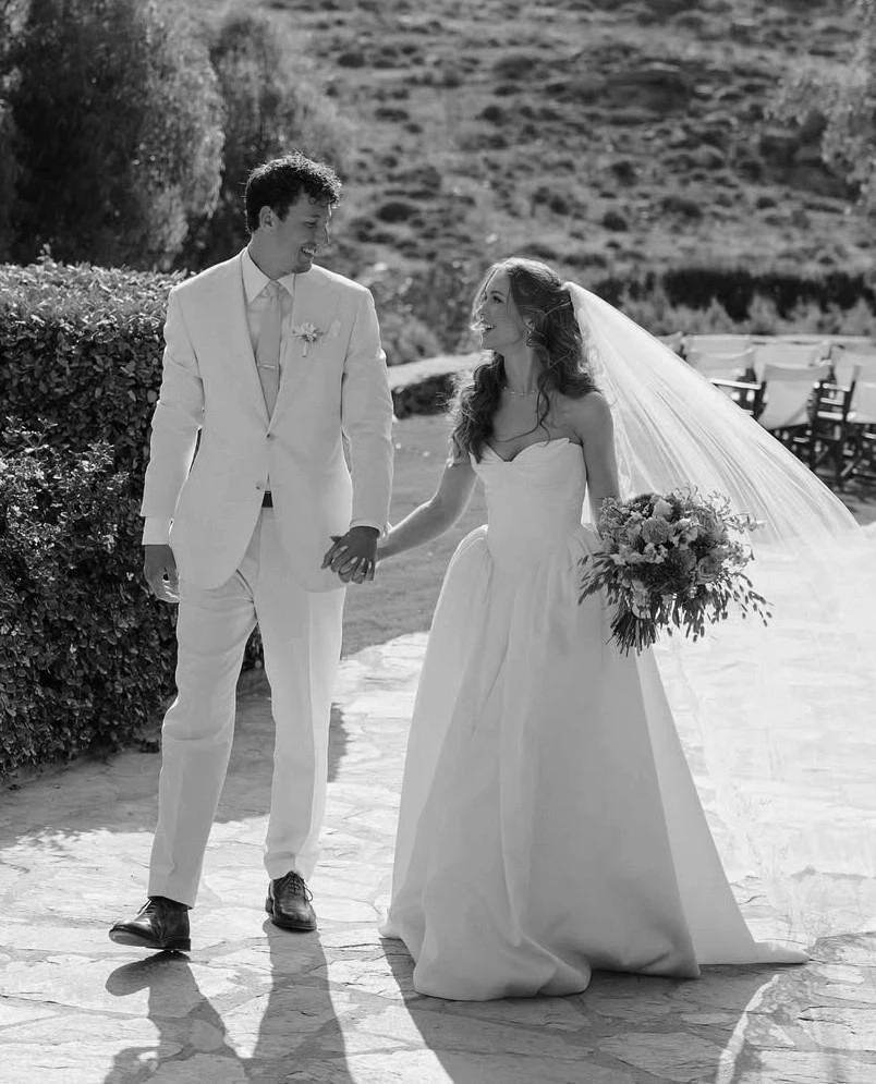 Morgan Davies Bridal Сouple wearing a white gown and a white suit